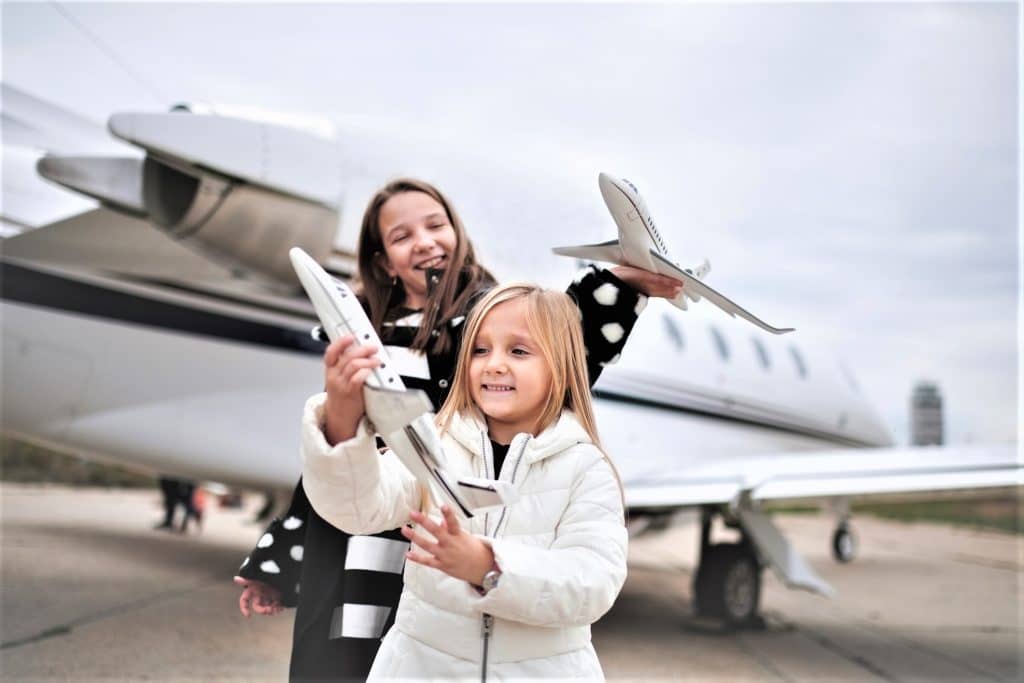 kids playing with white private jets